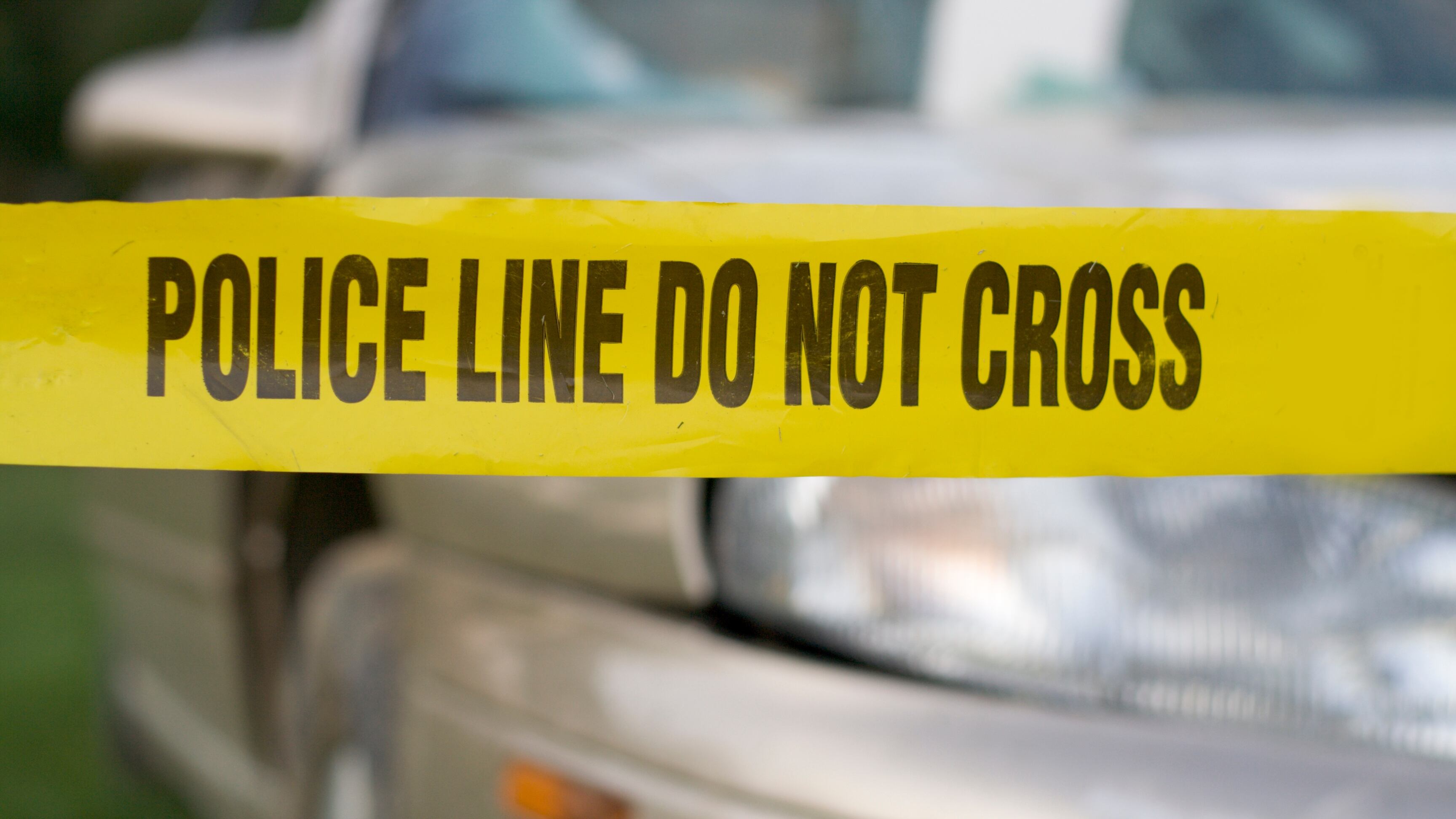 Police warning at an accident scene with a badly damaged car